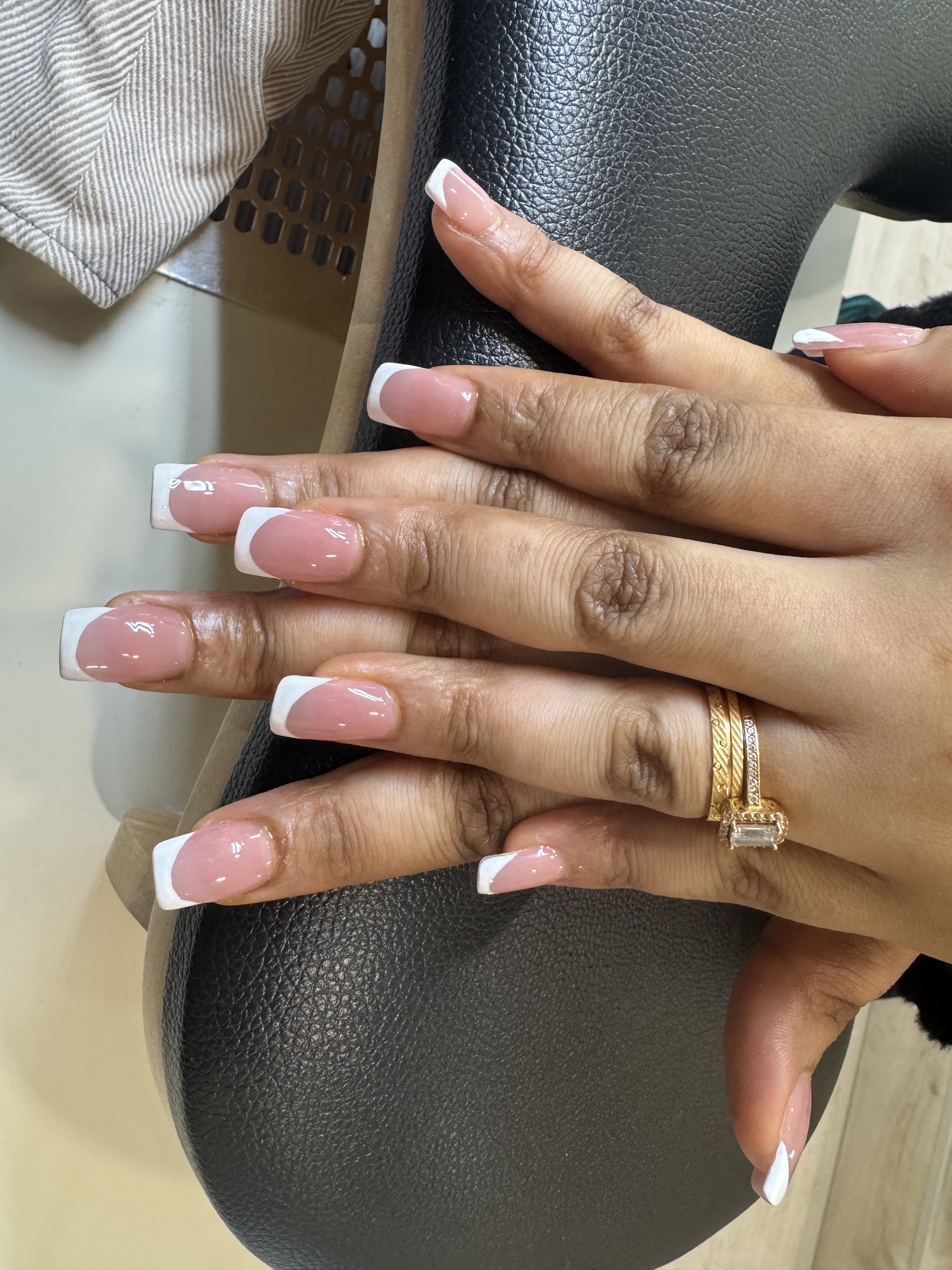 Verzorgde handen met een roze manicure en witte nagelranden