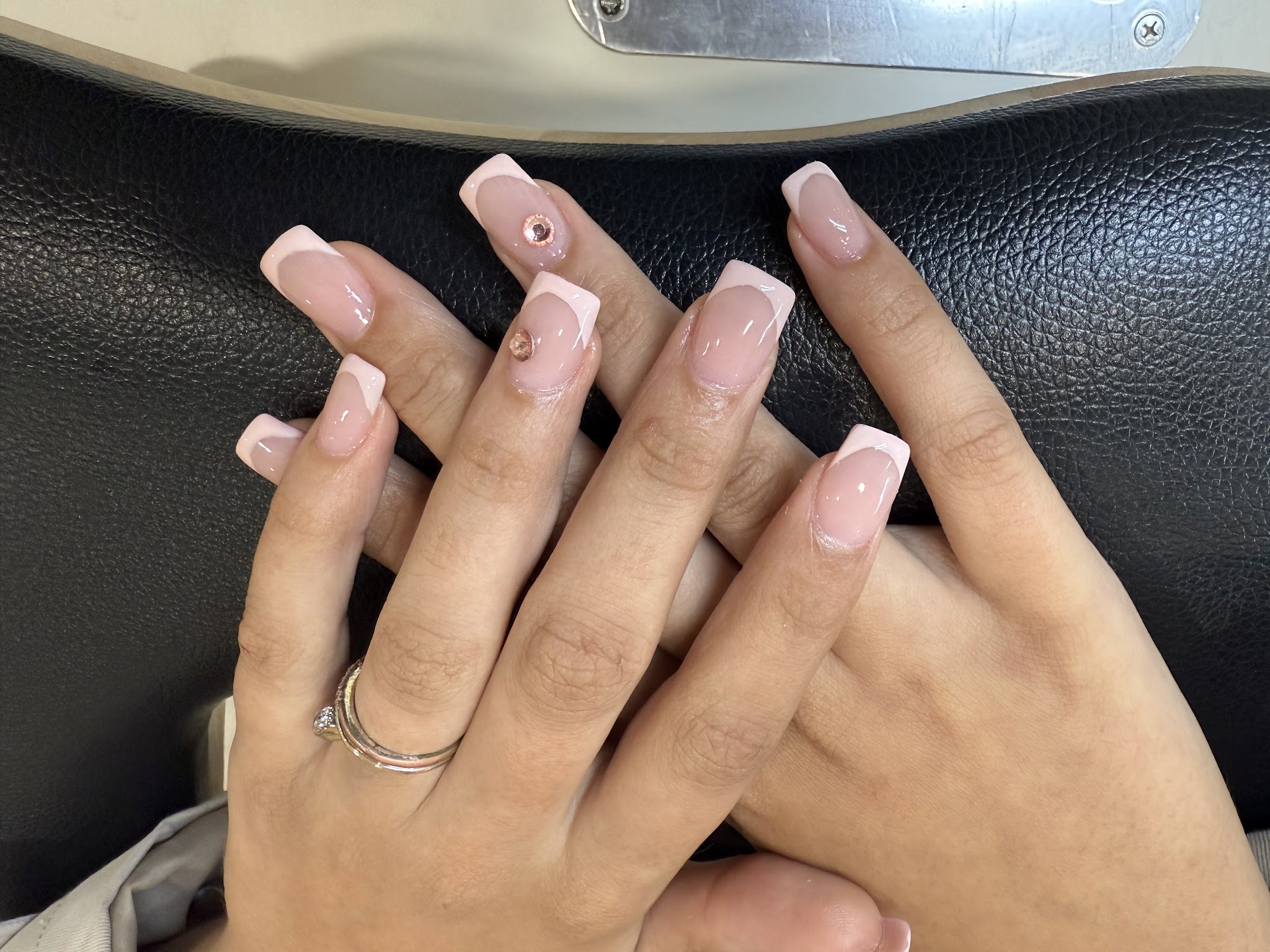 Afgewerkte roze manicure met witte nagelranden en subtiele versiering
